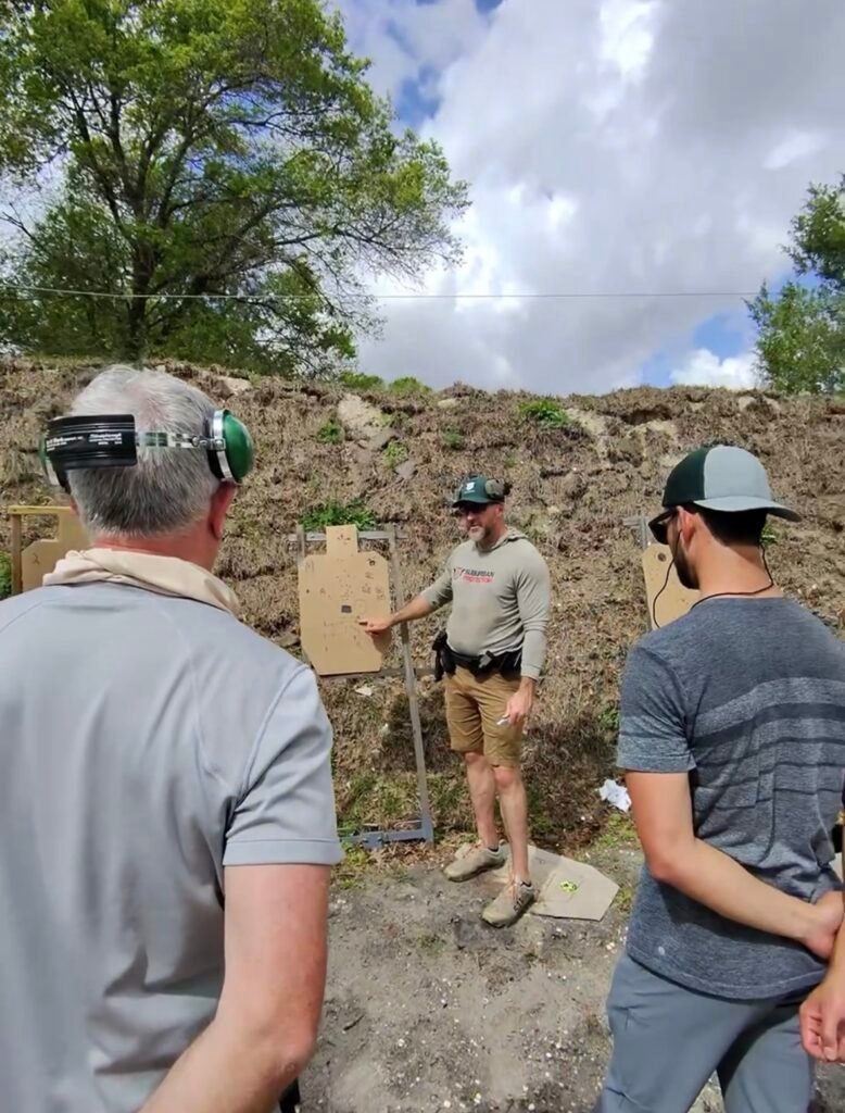 Instructor explaining safe gun handling to students at the range