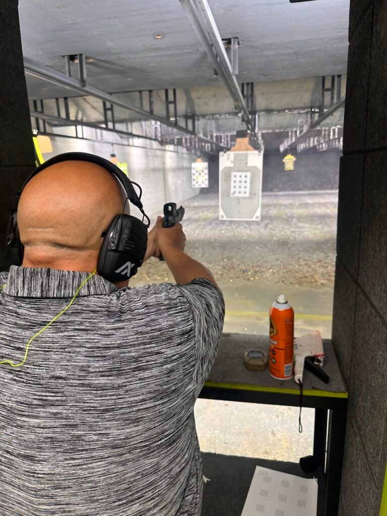 Student shooting a pistol in an indoor lane near Lake Worth Beach
