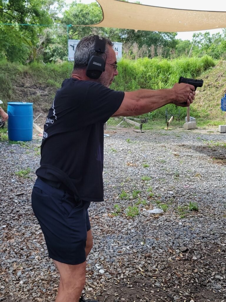 Student practicing pistol fundamentals at an outdoor range