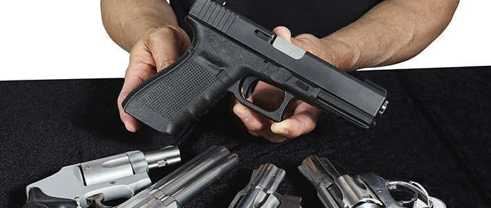 Several handguns laid out for a student to compare before buying